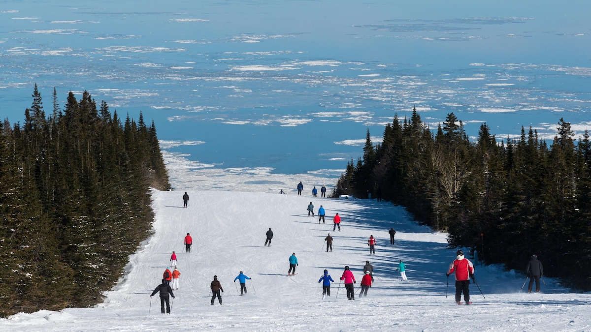 Le Massif de Charlevoix in Canada - a group of people skiing down a mountain.