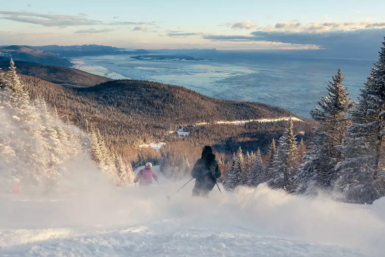 Le Massif de Charlevoix in Canada - a person skiing down a snowy slope in the mountains.
