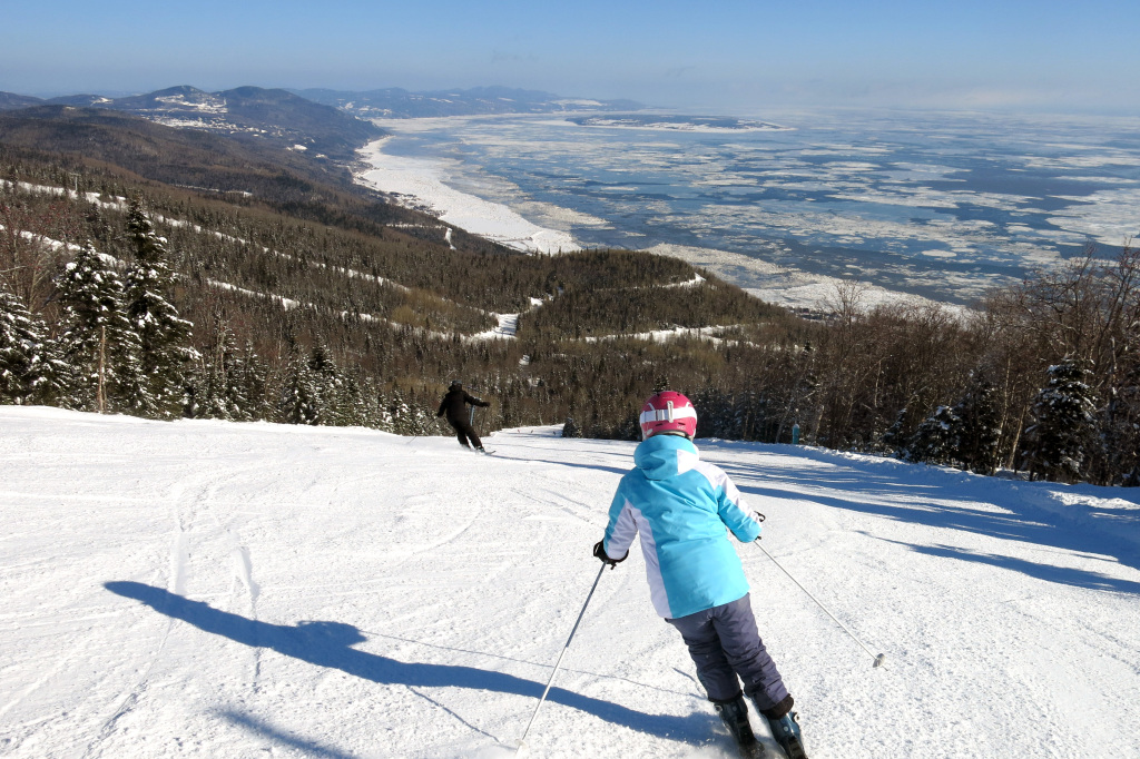 Le Massif de Charlevoix in Canada - a person skiing down a snowy slope in the mountains.