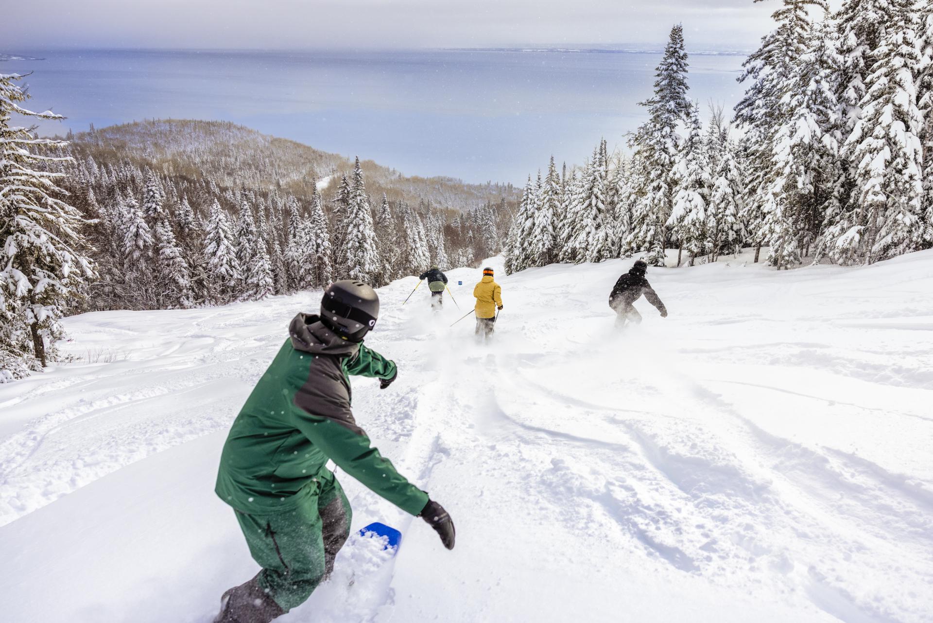 Le Massif de Charlevoix in Canada - a group of people skiing down a snowy slope.