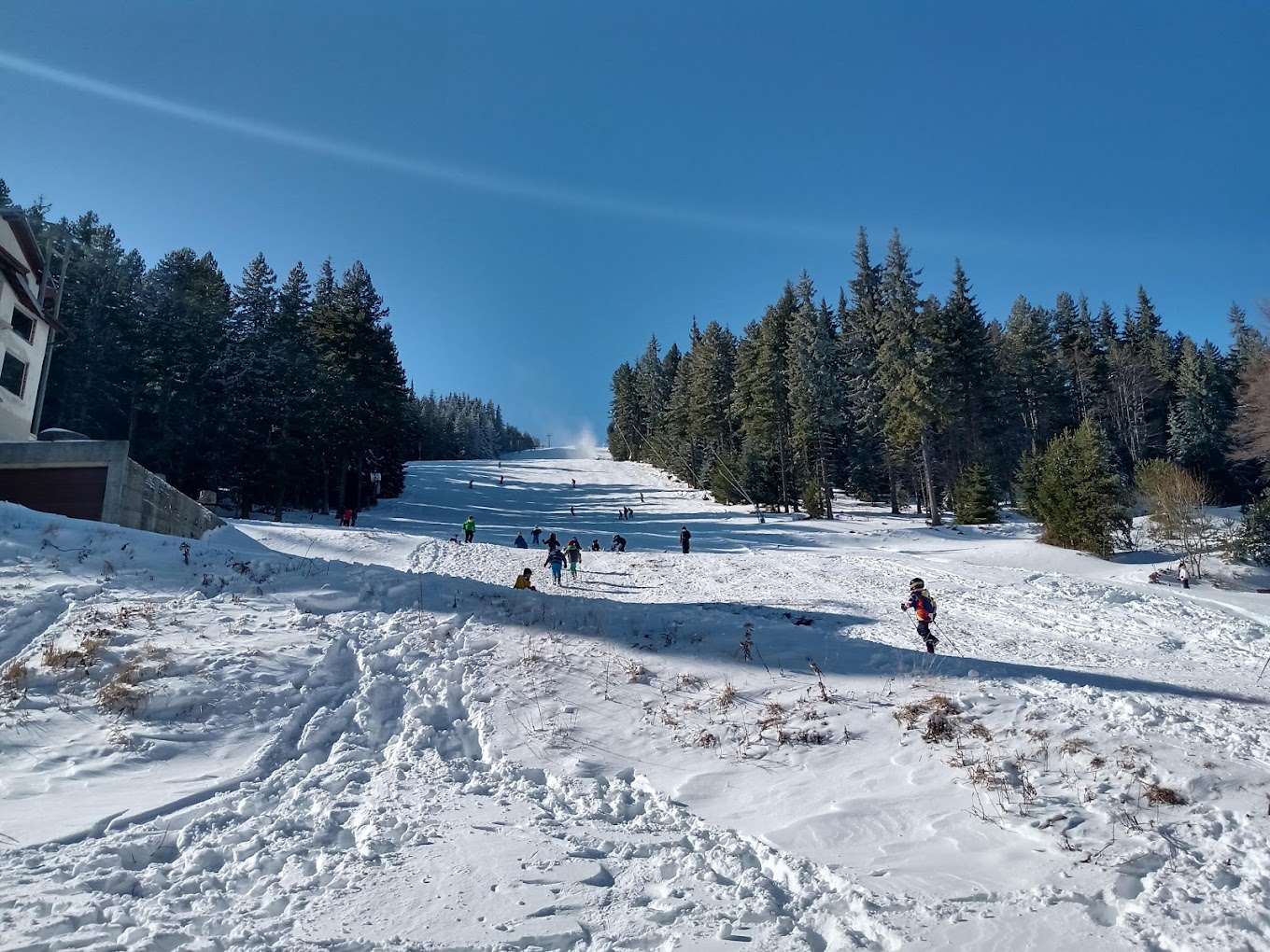 Ossogovo in Bulgaria - a group of people skiing down a snow covered slope.