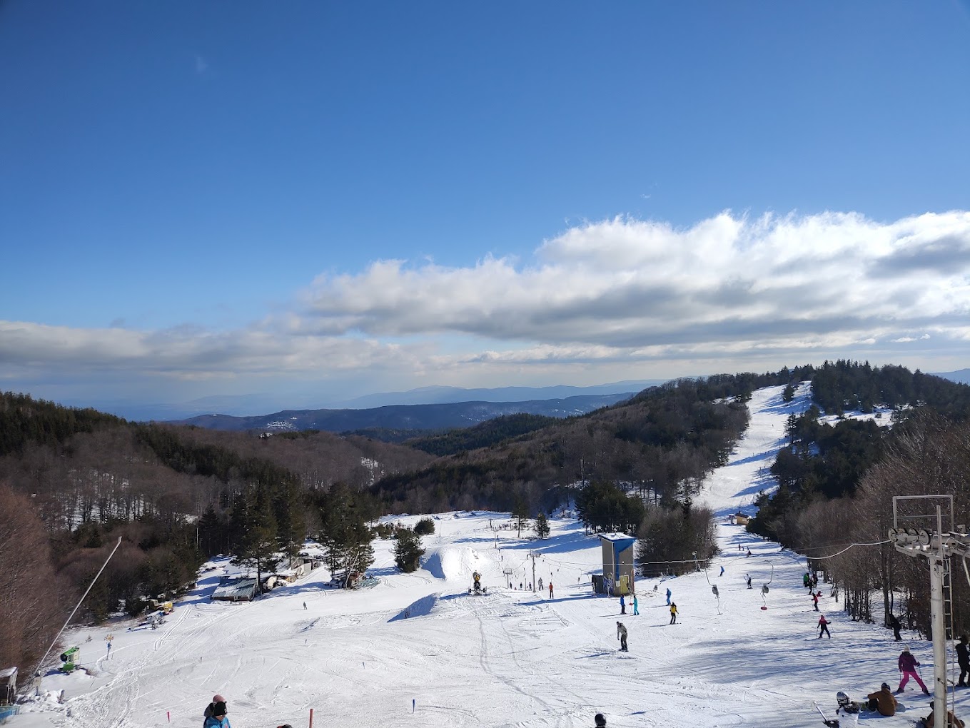 Ossogovo in Bulgaria - a ski slope with people skiing down it.