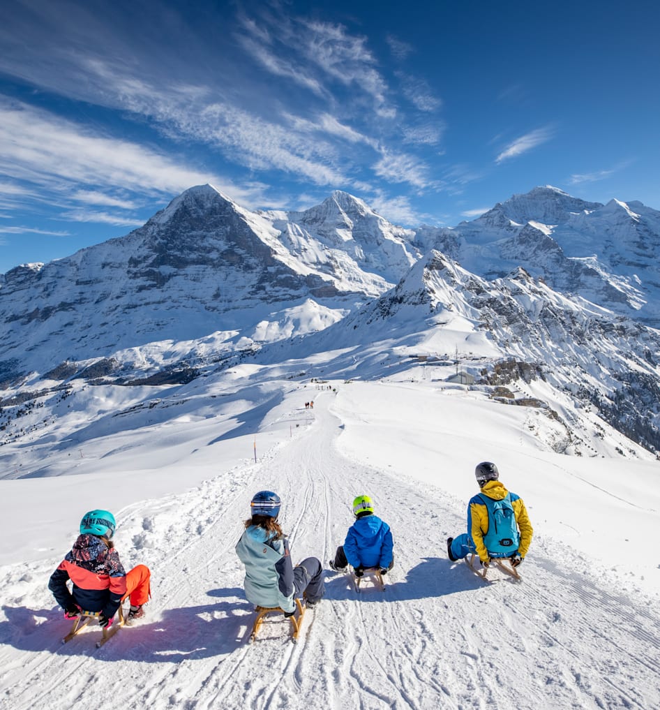 Kleine Scheidegg in Switzerland - a group of people sitting on top of a snowy mountain.
