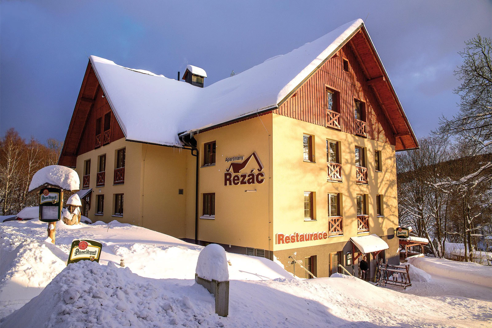 Udatný in Czech Republic: a yellow building with a red roof covered in snow.