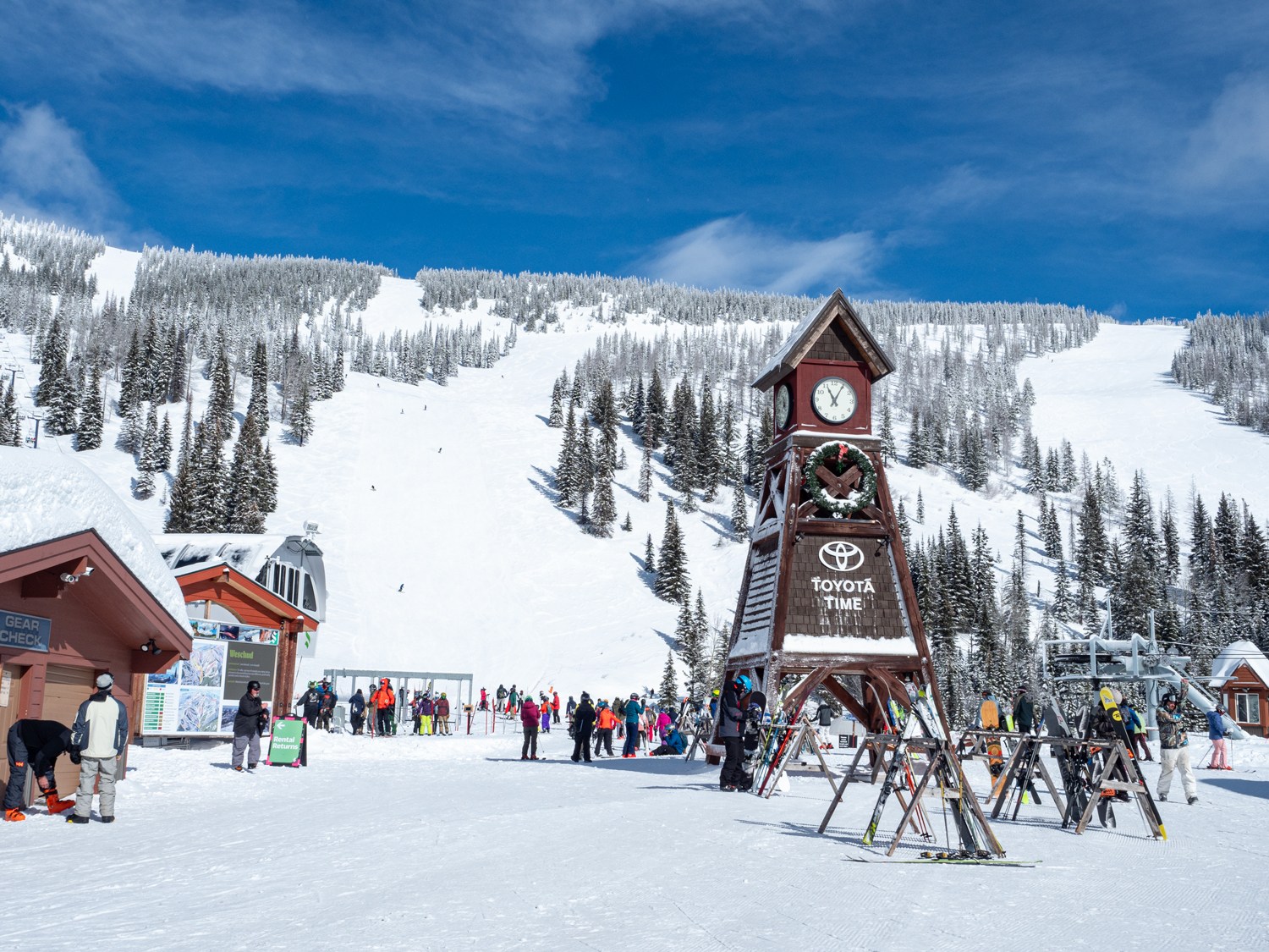 Schweitzer Mountain Resort in USA - a group of people standing around a clock in the snow.