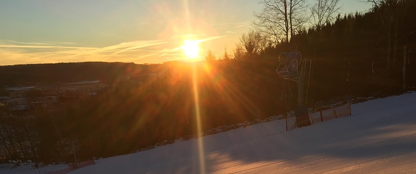 Vångabacken in Sweden - the sun is setting in the sky over a ski slope.