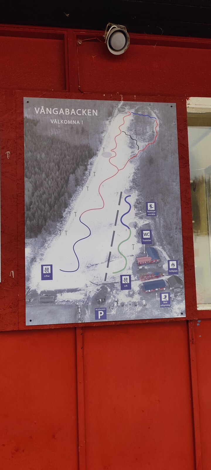 Vångabacken in Sweden: a sign on the side of a red building.