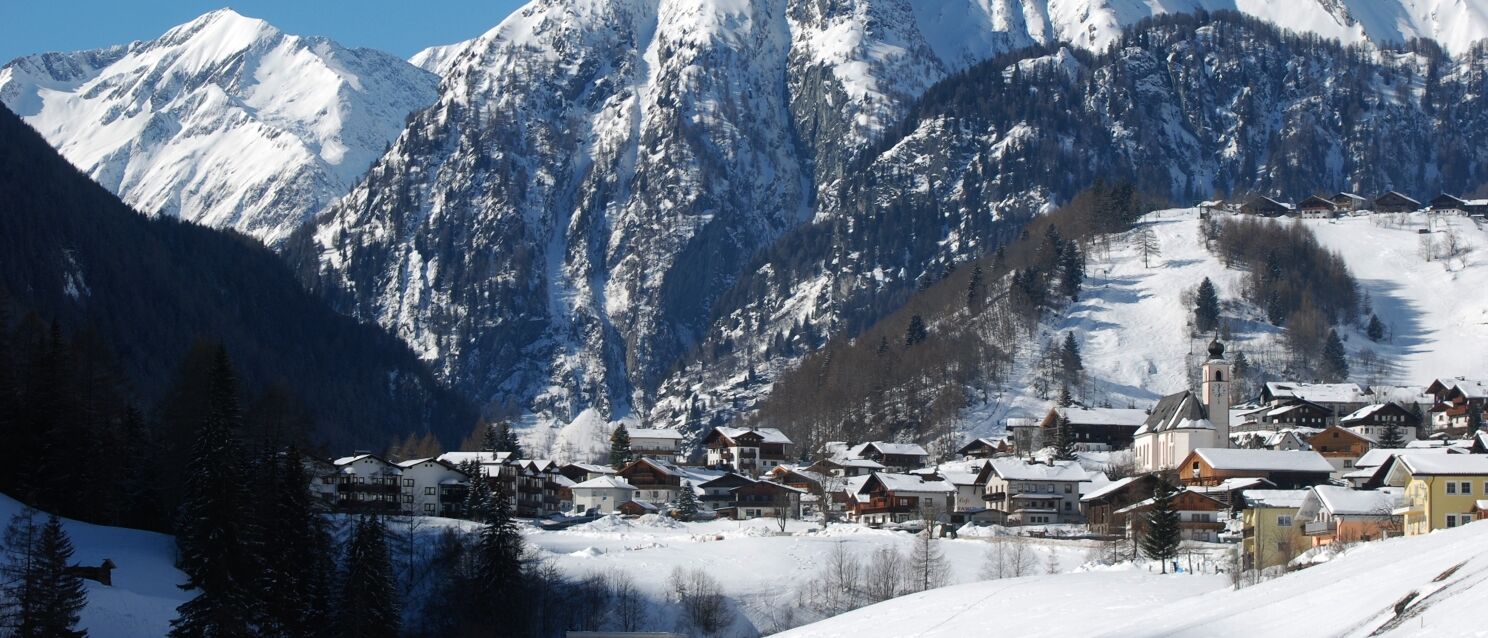 Grossglockner Heiligenblut in Austria - a snowy town with mountains in the background.