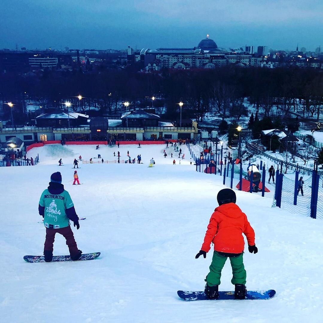 Park Szczęśliwice – Warsaw in Poland - a group of people riding snowboards on a snowy slope.