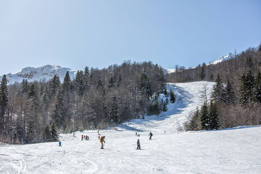 Winter sports scene at Kolašin ski resort in Montenegro, featuring a chalet, ski lift, and stunning winter scenery.