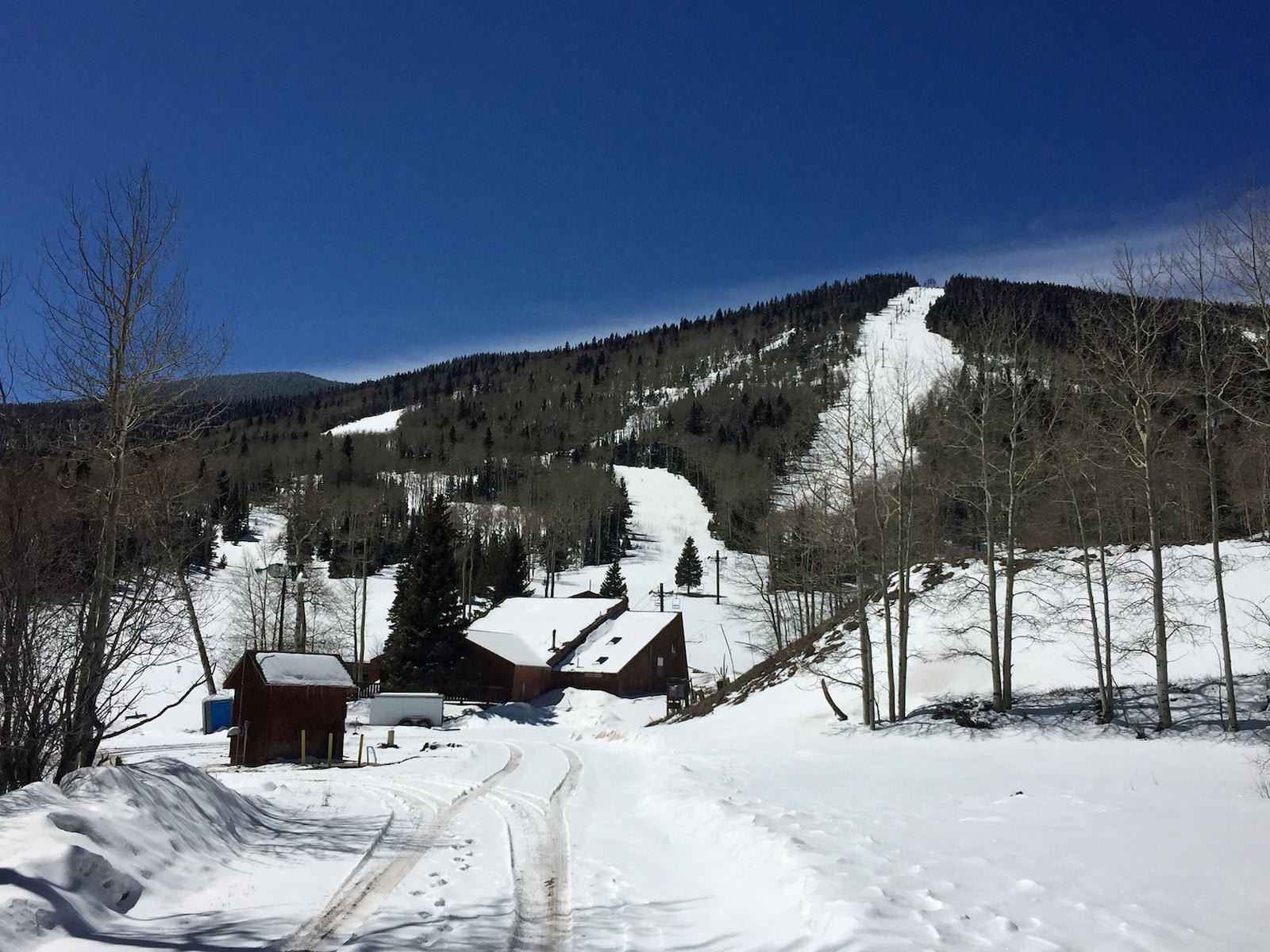 A vibrant winter sports scene at Cuchara Mountain Park Colorado with a ski resort charming chalet and ski lift set against the backdrop of a majestic mountain.