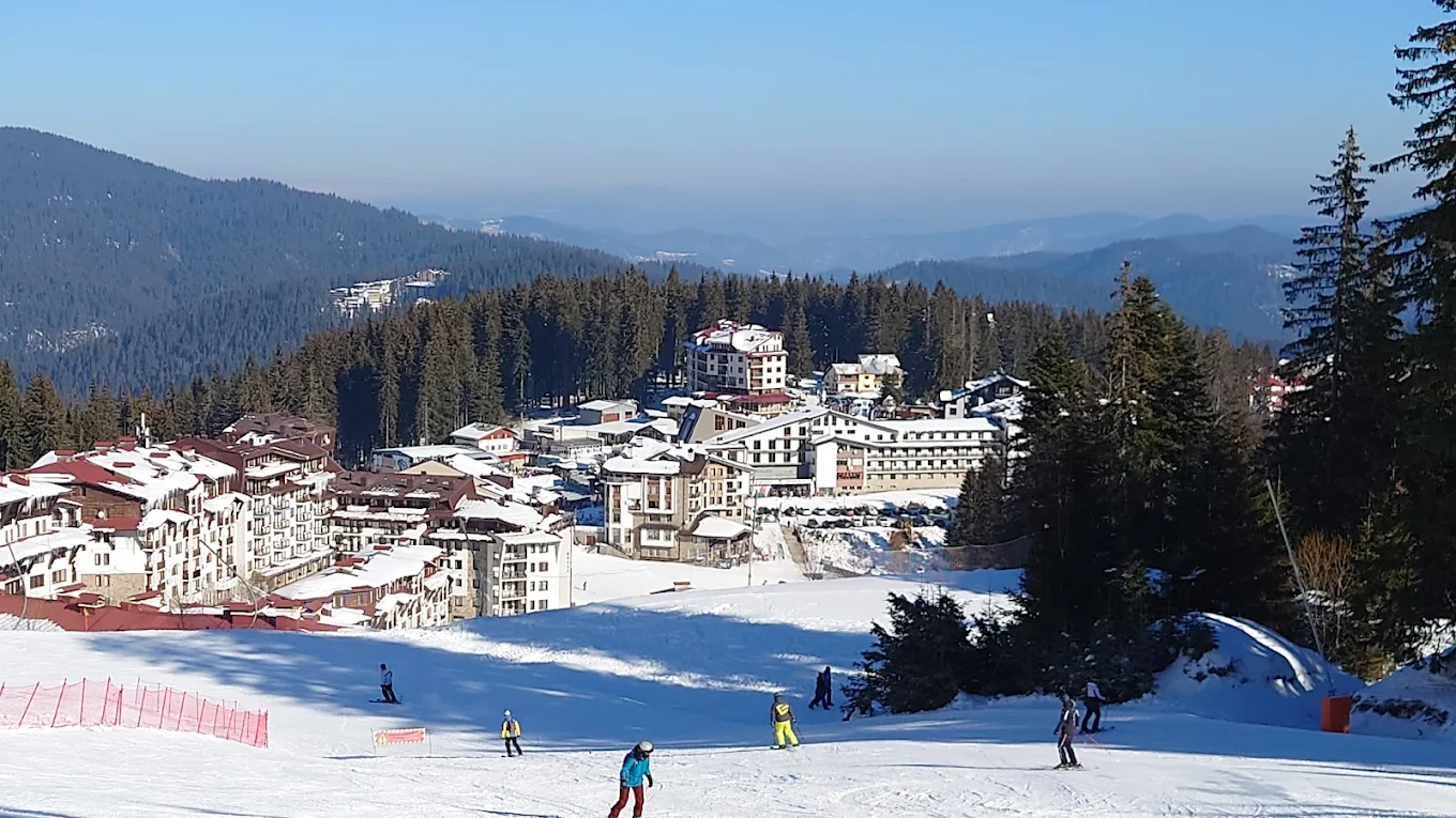 Pamporovo in Bulgaria - a group of people skiing down a snowy hill.