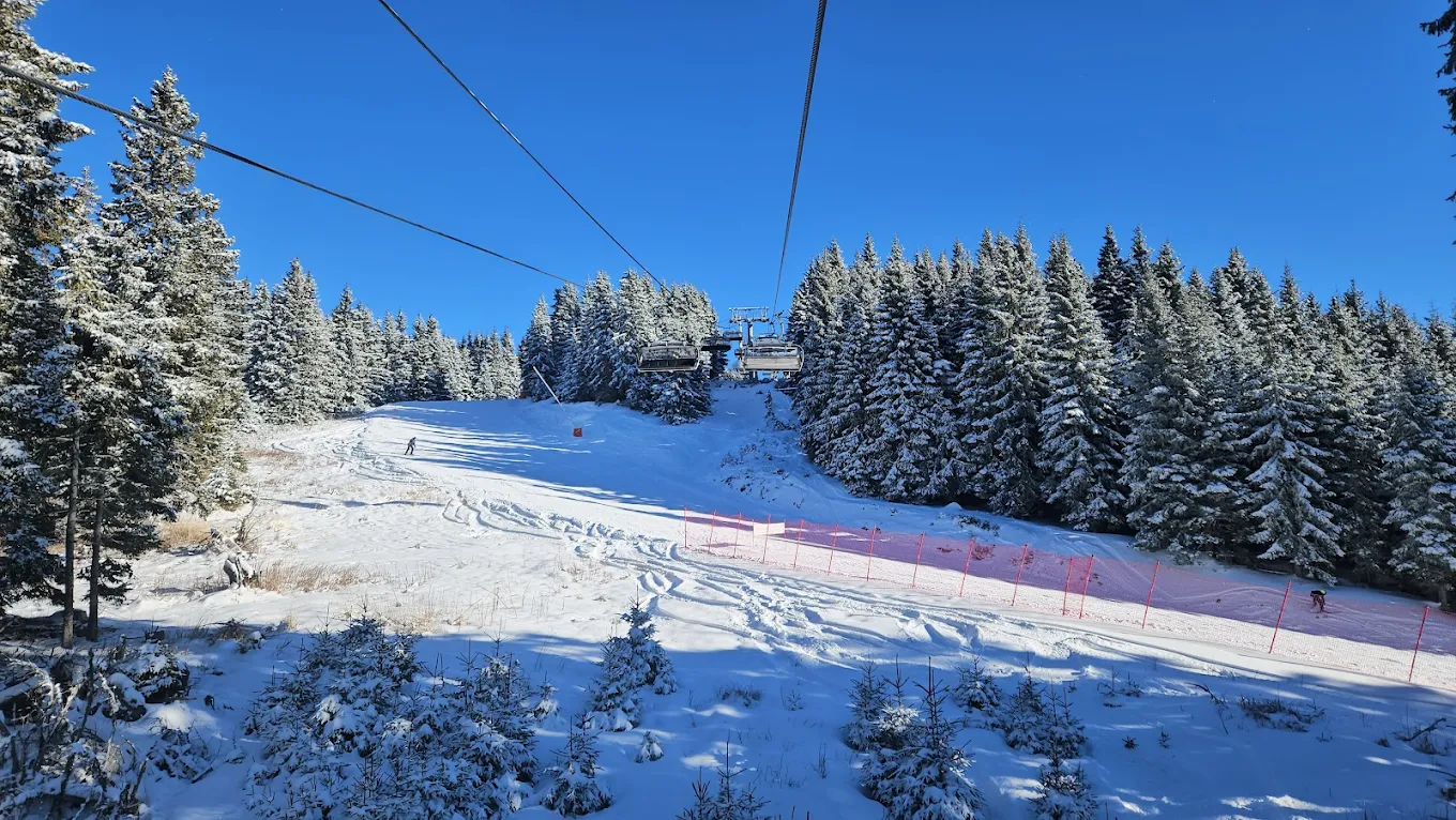 Pamporovo in Bulgaria - a ski lift going down a snowy slope.
