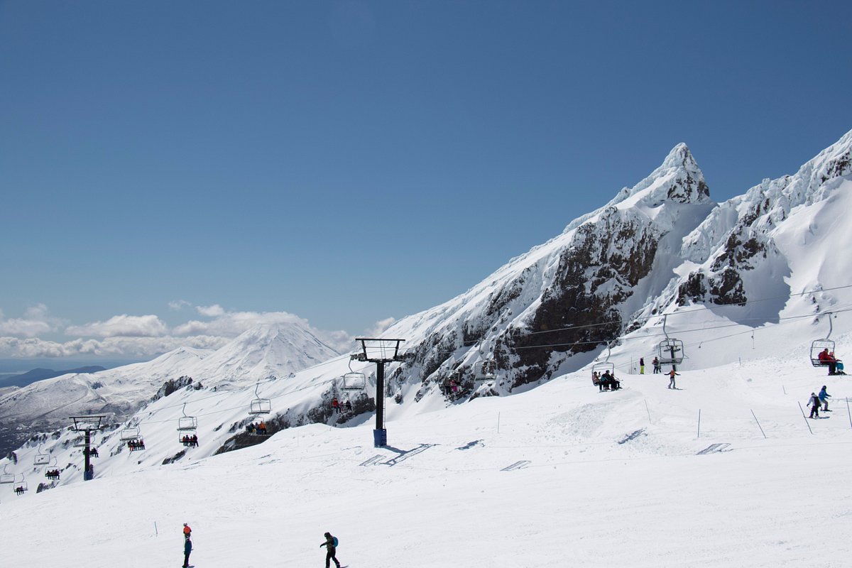 Whakapapa – Mt Ruapehu in New Zealand - a group of people skiing down a snowy mountain.