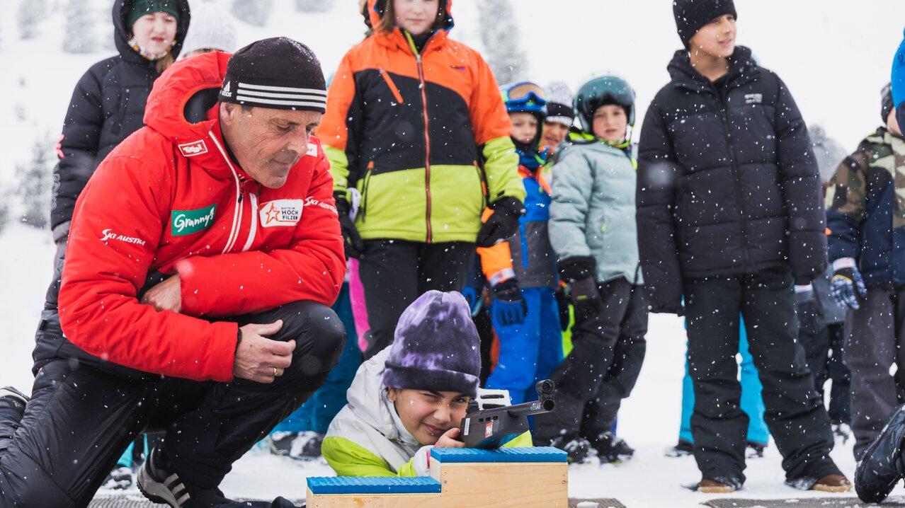 Pirstingerkogellift Sommeralm in Austria - a man kneeling in the snow with a child.