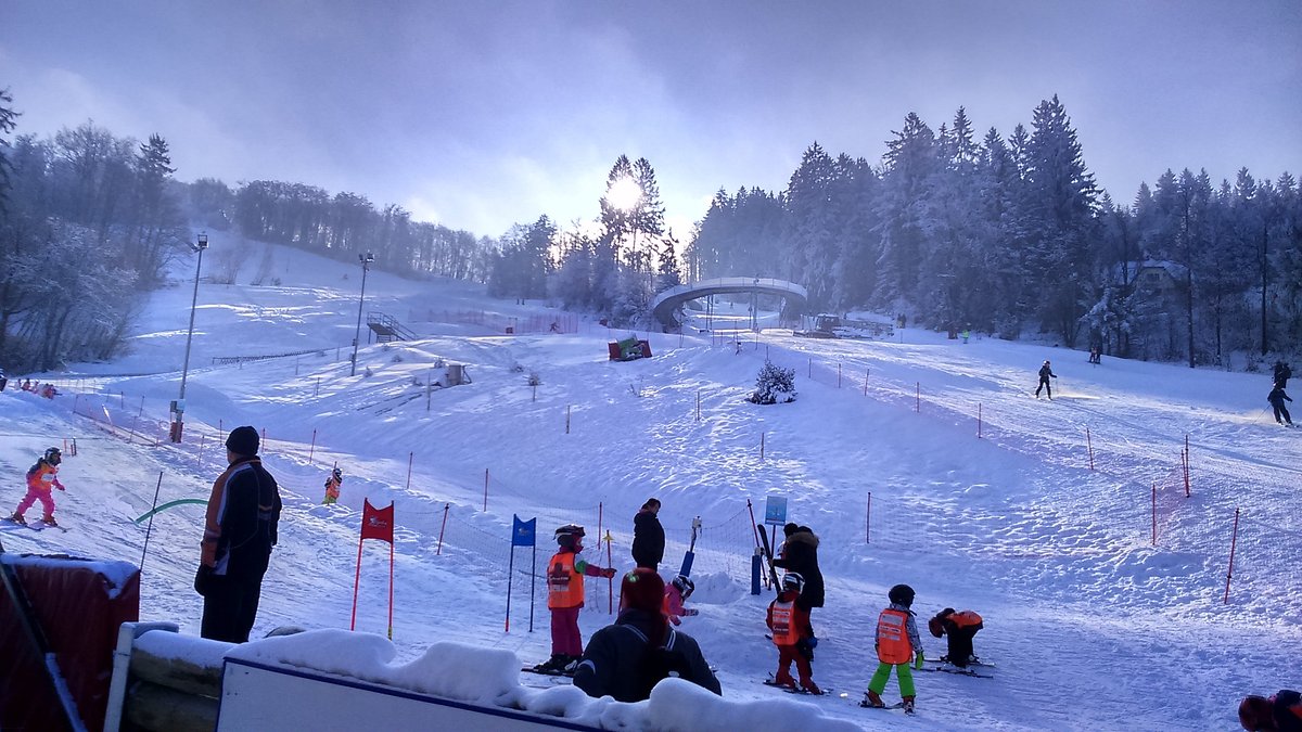 Celjska koča in Slovenia - a group of people standing on top of a snow covered slope.