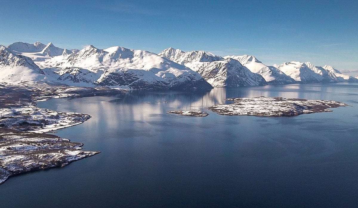 Lyngseidet in Norway - a large body of water surrounded by snow covered mountains.