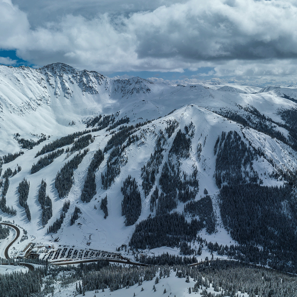 Arapahoe Basin in USA - a view of a snowy mountain with a train going through it.