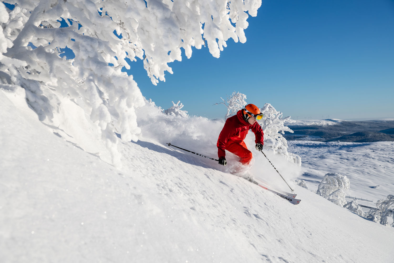 Backes Skidanläggning in Sweden - a person in a red jacket skiing down a mountain.