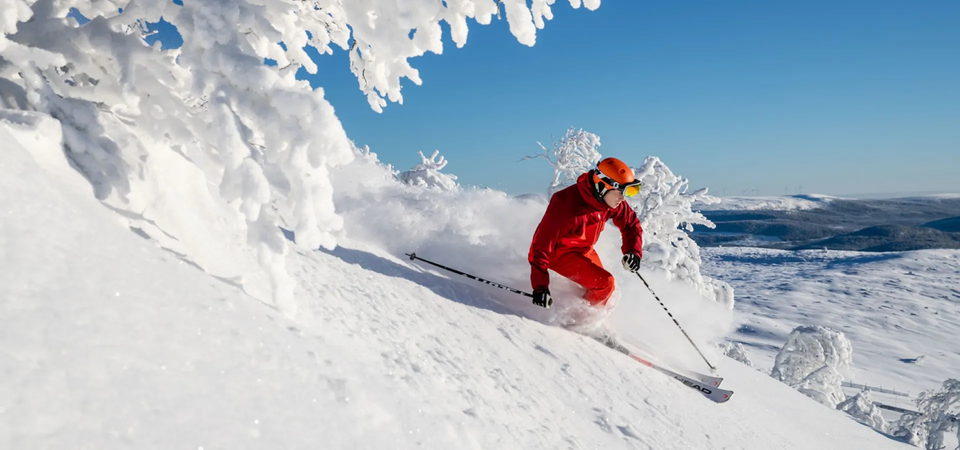 Backes Skidanläggning in Sweden - a person skiing down a snowy slope in the mountains.