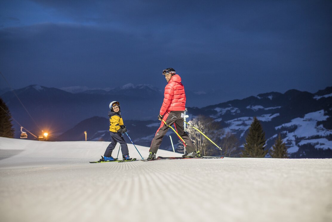 Roggenboden in Austria - a couple of people skiing down a snowy slope.