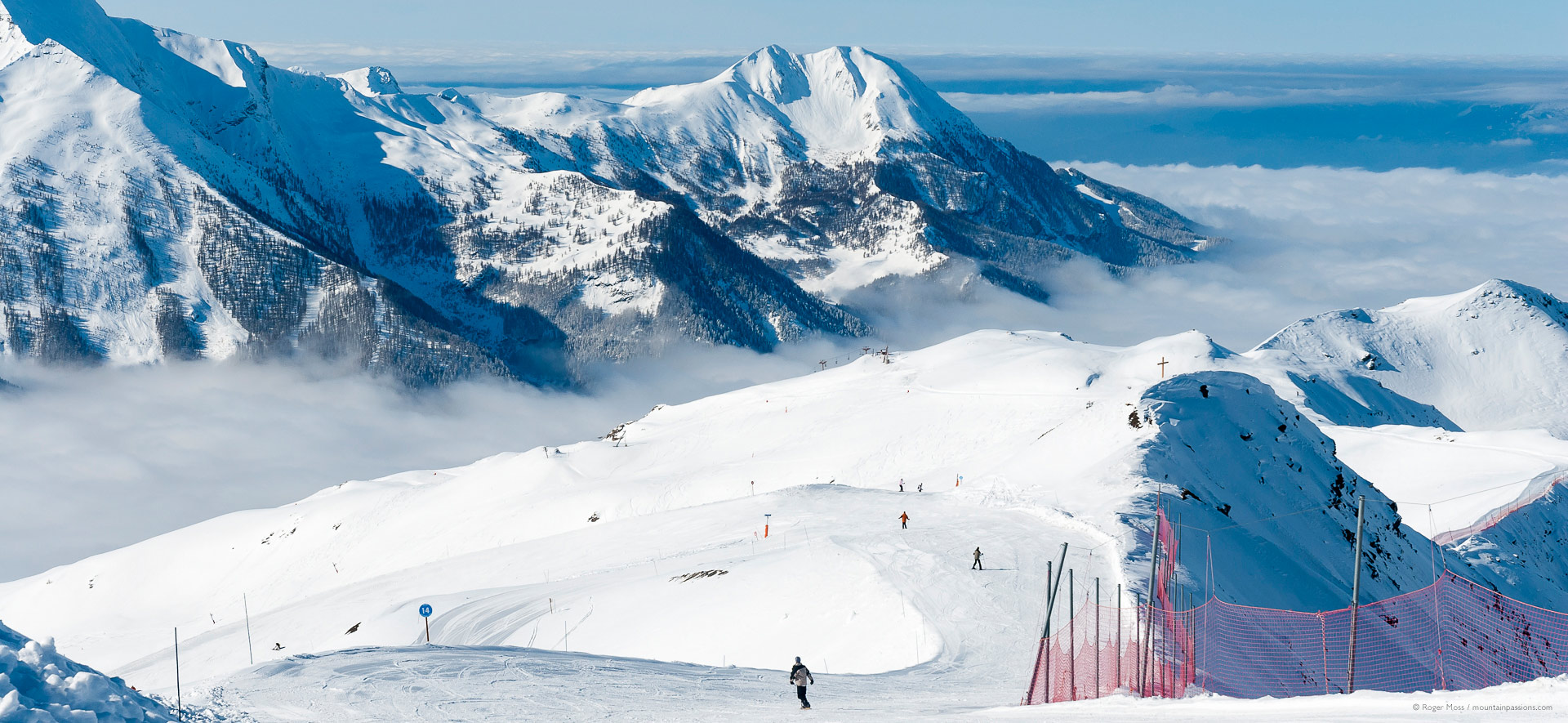 Orcières Merlette 1850 in France - a group of people skiing down a snowy mountain.