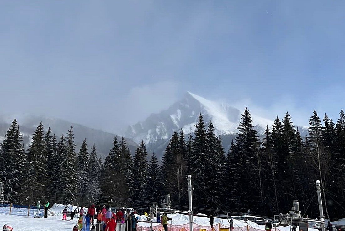 Podbanské in Slovakia - a group of people skiing down a snow covered slope.