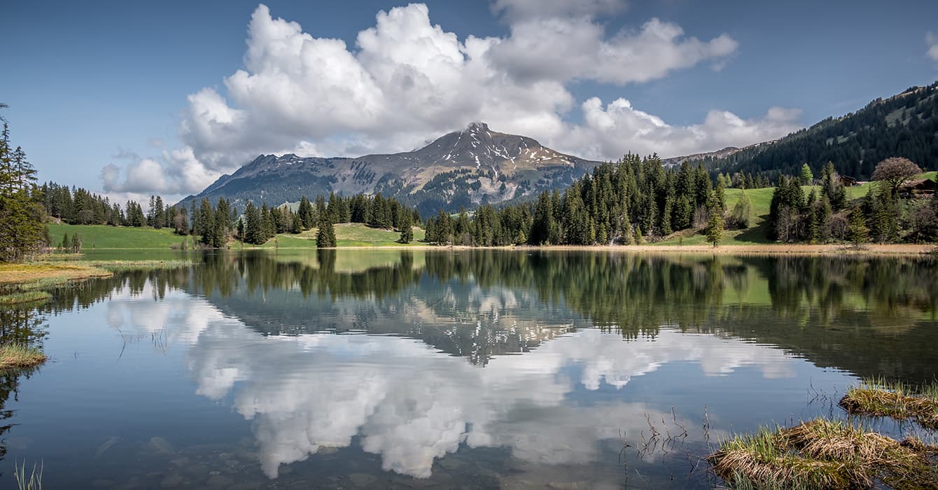 Lauenen in Switzerland - a lake with a mountain in the background.