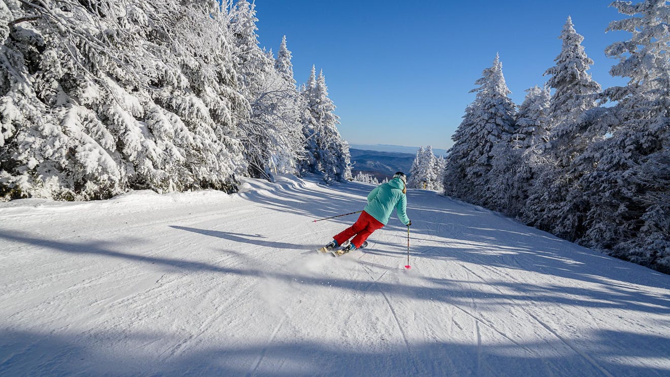 Stratton Mountain Resort in USA - a person skiing down a snow covered mountain.