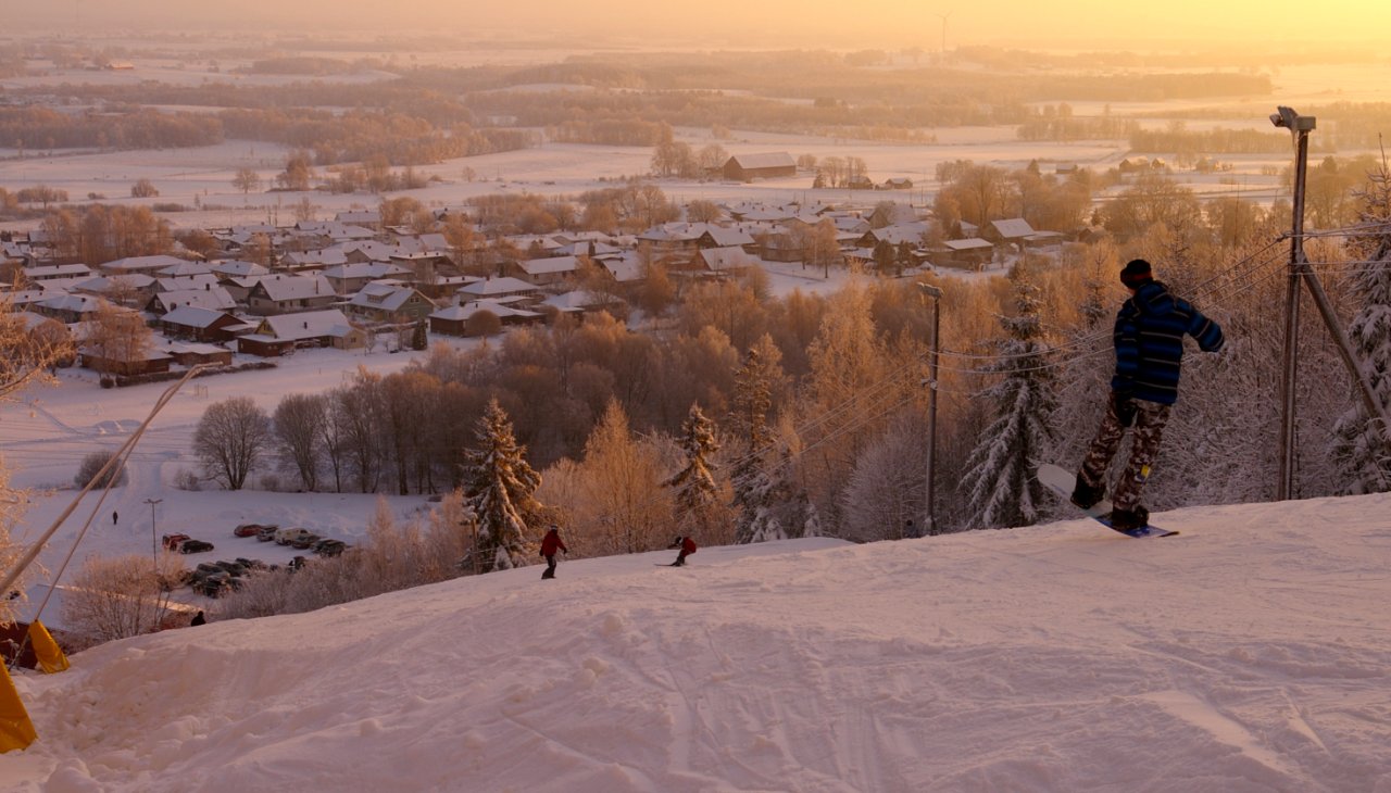 Mössebergsbacken – Falköping in Sweden - two people skiing down a snowy hill at sunset.