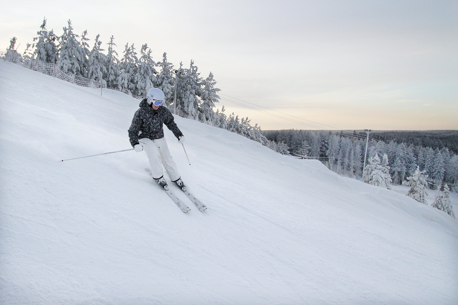 Sveitsin Hiihtokeskus – Hyvinkää in Finland - a person skiing down a snowy hill.