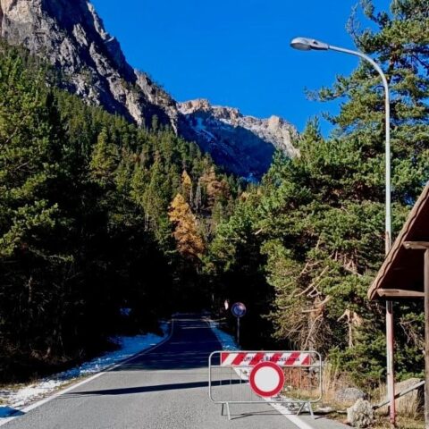 A picturesque chalet nestled in the snow-covered slopes of Bardonecchia in Turin, Piedmont, Italy, with a backdrop of majestic mountains looming in the distance.