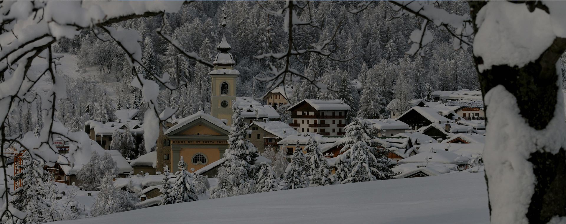 Snowy landscape at Bardonecchia in Turin, Piedmont, Italy, featuring a bustling winter sports scene, a winter sports center, and quaint mountain chalet, framed by striking winter scenery and a popular ski resort.