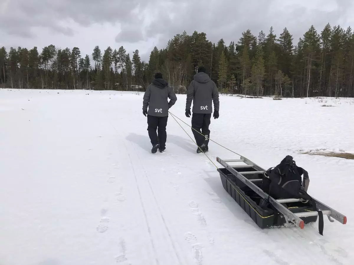 Junsele in Sweden - two people are pulling a sler through the snow.