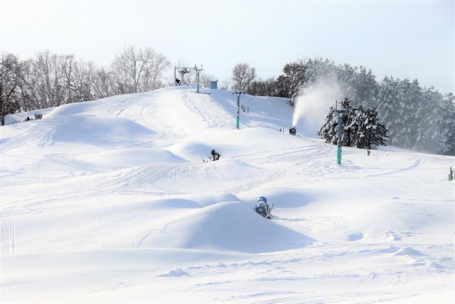 Winter sports scene at Whitetail Ridge, Fort McCoy, Wisconsin, featuring prominent elements like a ski resort, ski trails, a skier in action, and stunning winter scenery.
