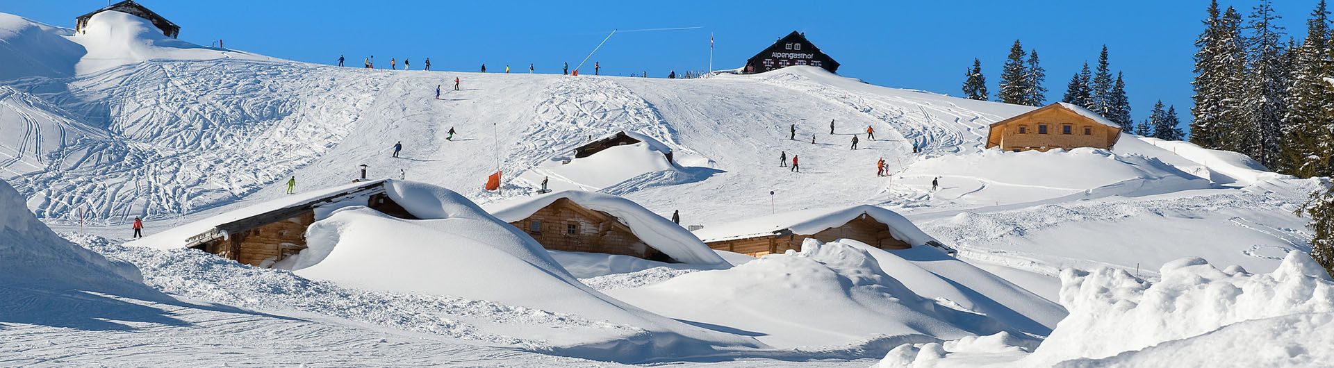 Almenwelt Lofer in Austria - a group of houses on a snow covered mountain.