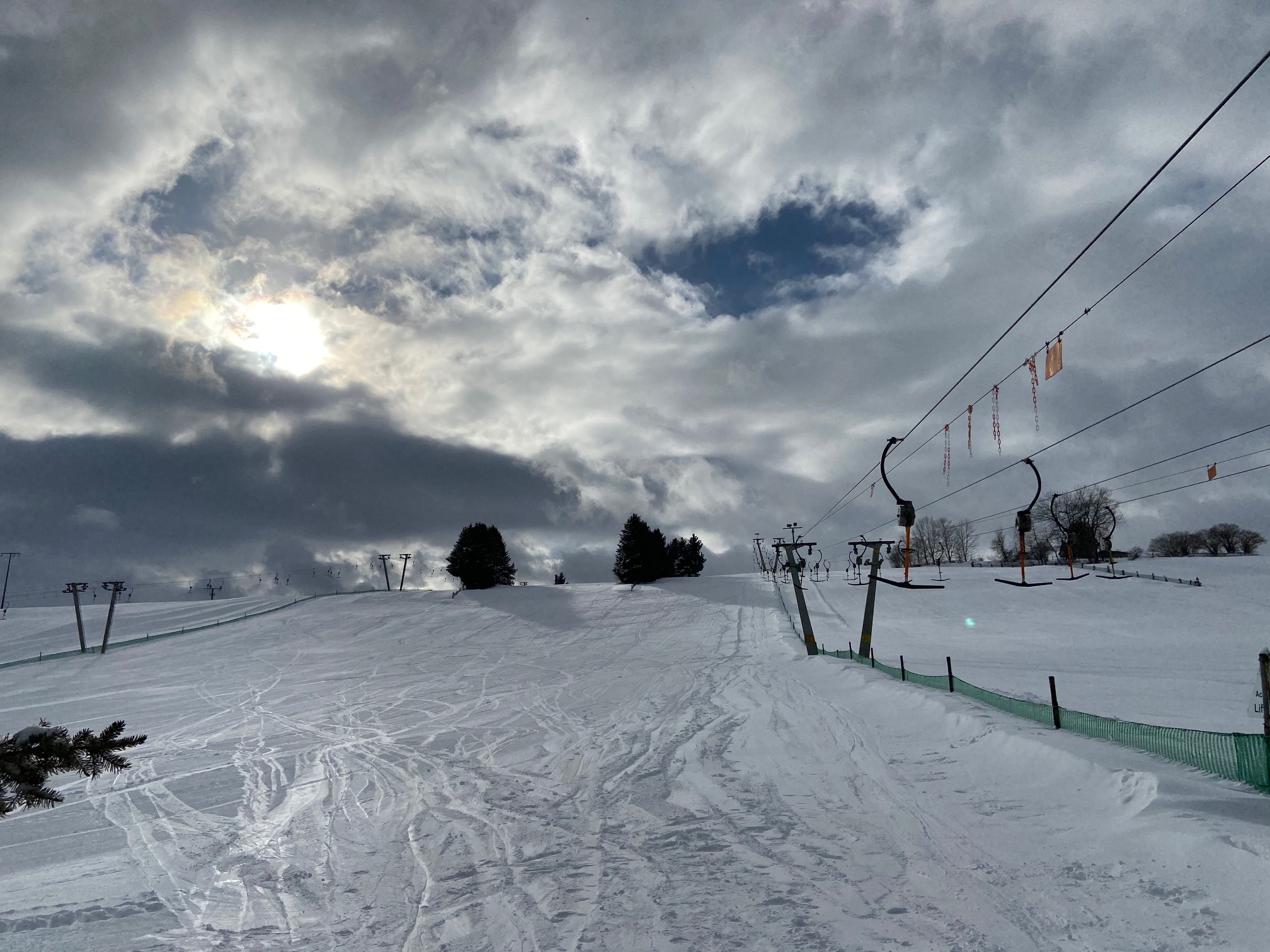 Am Richtergrund – Hermsdorf in Germany - a snow covered ski slope under a cloudy sky.