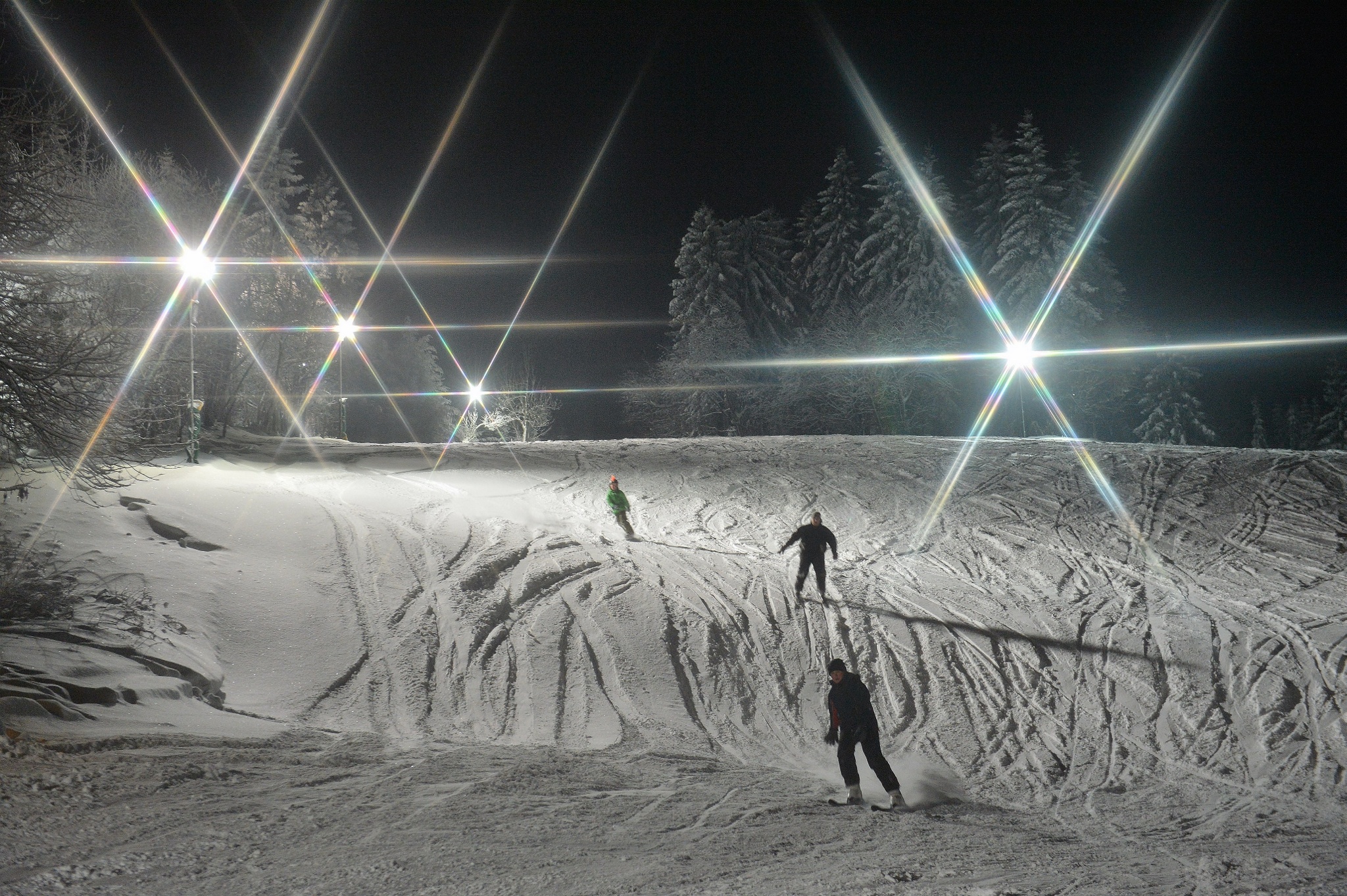 Am Richtergrund – Hermsdorf in Germany - a person skiing down a snowy slope at night.