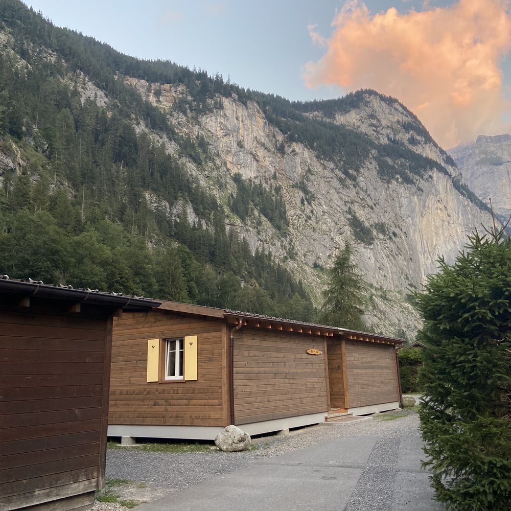 Heiti – Gsteig bei Gstaad in Switzerland - a wooden cabin with mountains in the background.