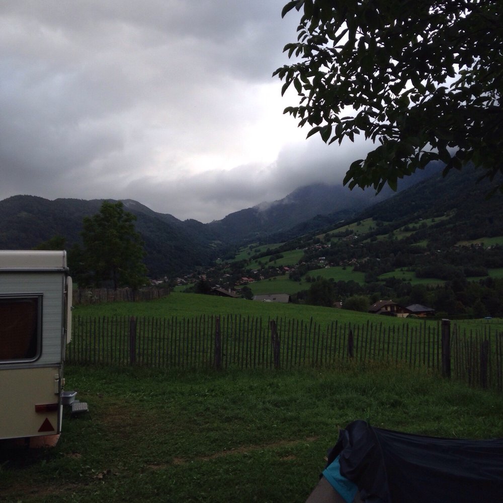 Heiti – Gsteig bei Gstaad in Switzerland - an rv parked in a field with mountains in the background.