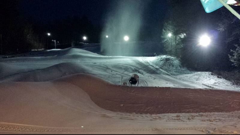 A skier enjoying a winter day at Storrs Hill Ski Resort in Lebanon, New Hampshire, surrounded by snow-covered chalet and winter sports facilities.