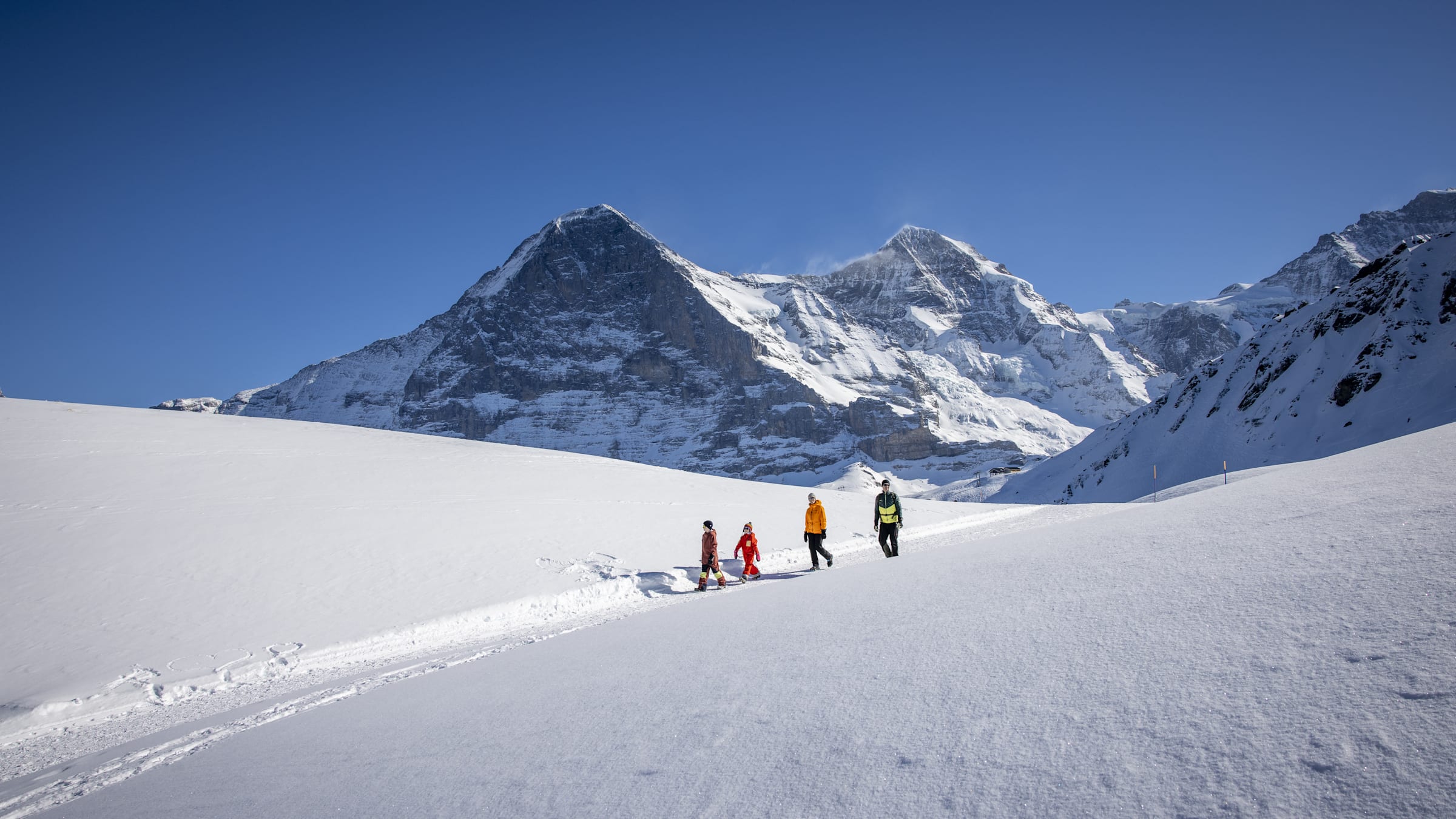 Wengen in Germany - a group of people walking up a snow covered mountain.