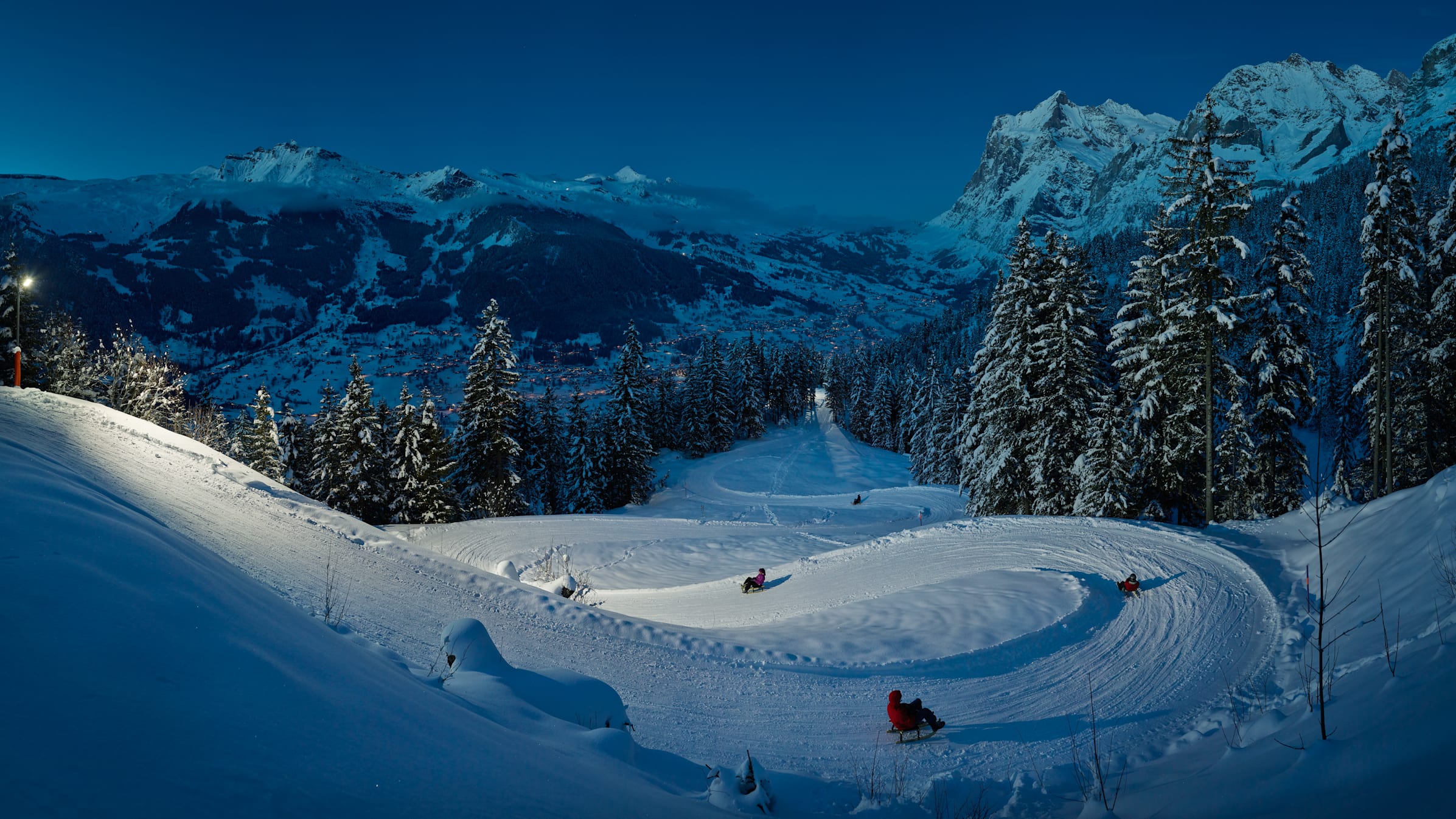 Wengen in Germany - a group of people skiing down a snow covered mountain.
