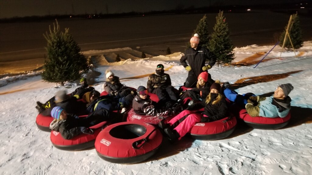 Spring Hill Winter Park in Canada - a group of people riding tubes down a snow covered hill.
