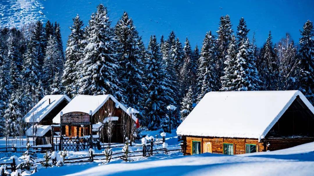A picturesque winter sports scene at Ji kepulin – Hemu in Xinjiang, China, featuring encompassing winter scenery, a bustling ski resort, and a sports centre against a stunning backdrop.