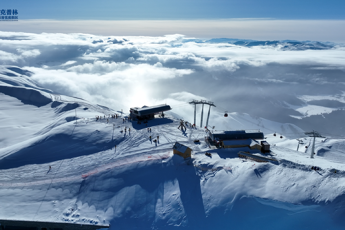 View of Ji kepulin-Hemu ski resort in Xinjiang China showcasing a vibrant winter sports scene. Traces of a ski lift and a chalet can also be seen in the picturesque snowy landscape.