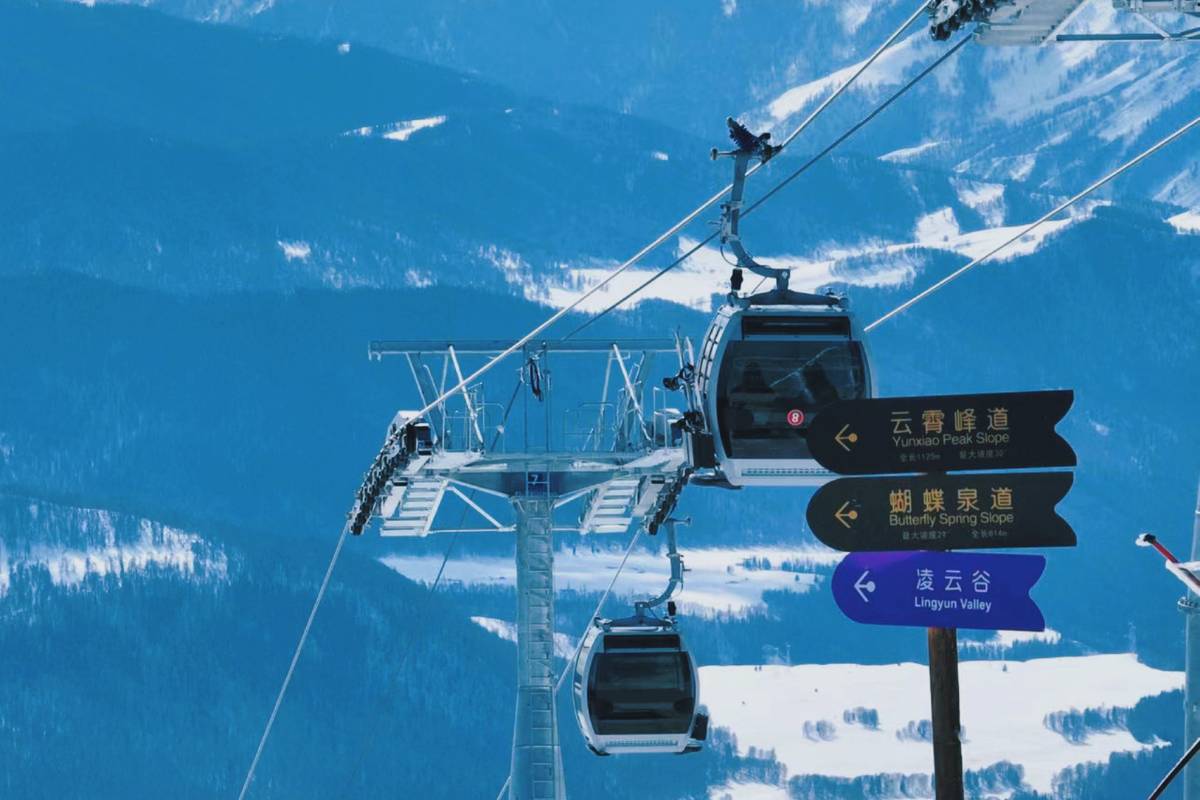 A captivating winter scene at Ji kepulin – Hemu ski resort in Xinjiang China featuring a ski lift skidome a flurry of skiers and a beautiful chalet nestled in the snowy landscape.