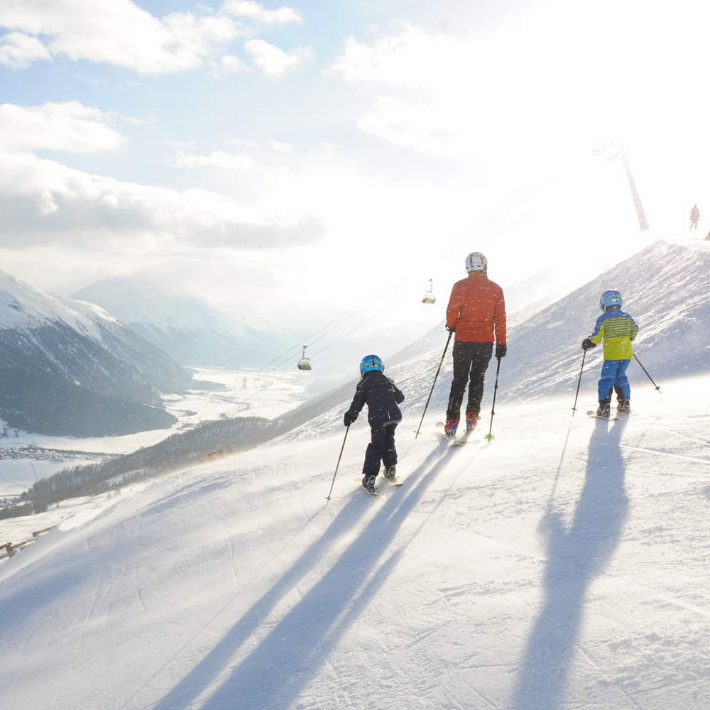 Zuoz – Pizzet | ​Albanas in Switzerland - a group of people skiing down a mountain.