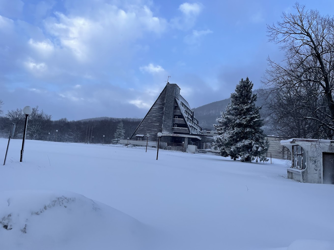Velebno in Croatia - a house in the snow with trees in the background.