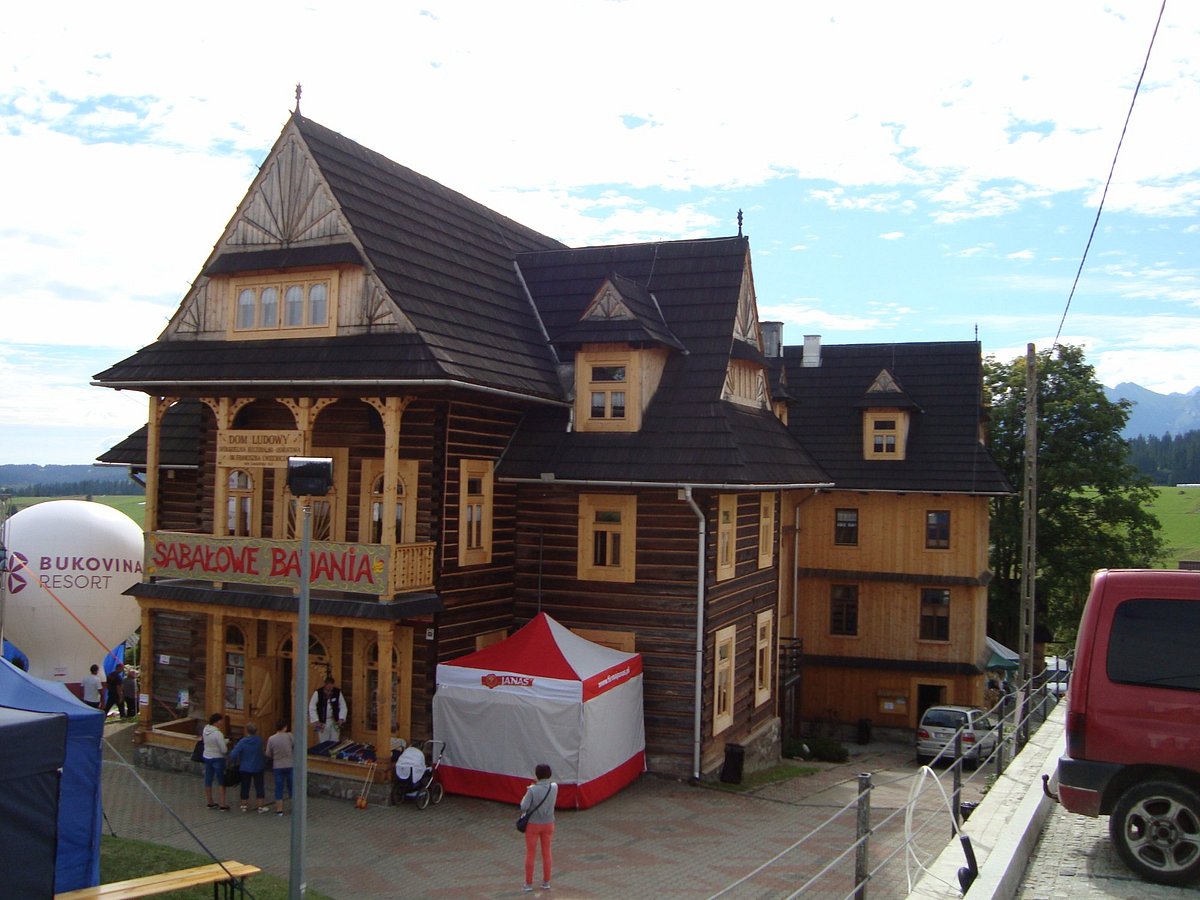 Szymkówka in Poland: a large wooden building with a sign on the front.